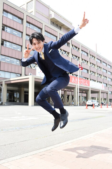 秋田県庁の前でジャンプするユースケ。