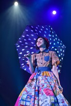 青い傘を手に「Rain」を歌う安本彩花。