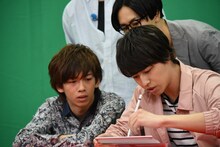 問題を解くタカシ（右）と、彼を見守るリョウガ（左）、タクヤ（奥）。