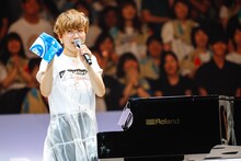 オーディエンスに記念品としてプレゼントした手ぬぐいを紹介する福岡晃子。（撮影：上山陽介）