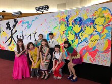 「世界はあなたに笑いかけている」MVの出演者と記念撮影するLittle Glee Monster。