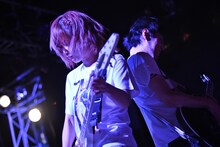 背中合わせでギターをかき鳴らす藤田恵名（左）と田渕ガー子（右）。