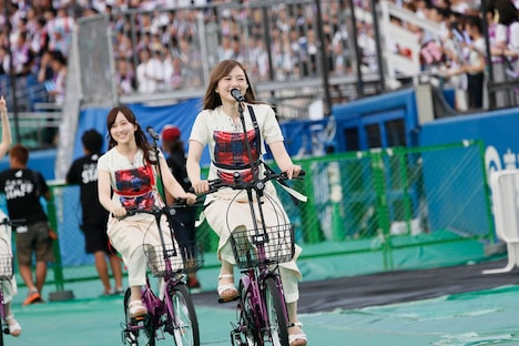 自転車に乗って移動する白石麻衣（手前）と星野みなみ（奥）。