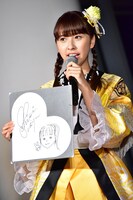 自身の自画像を持つ玉井詩織。