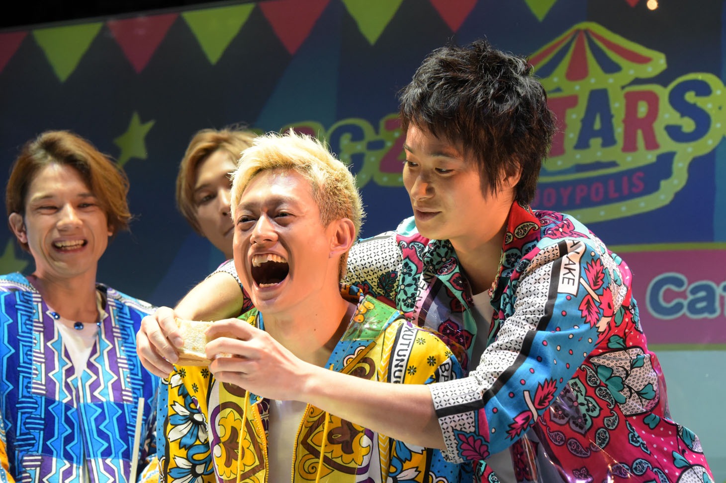 塚田僚一（左）にサンドイッチを食べさせる戸塚祥太（右）。