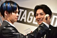 ユースケ（右）の頬に色を乗せるカイ（左）。