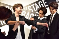 リョウガに右腕をメイクしてもらい、タクヤに左腕を腕まくりしてもらうユーキ（左から2番目）と、3人を見守るタカシ（右）。