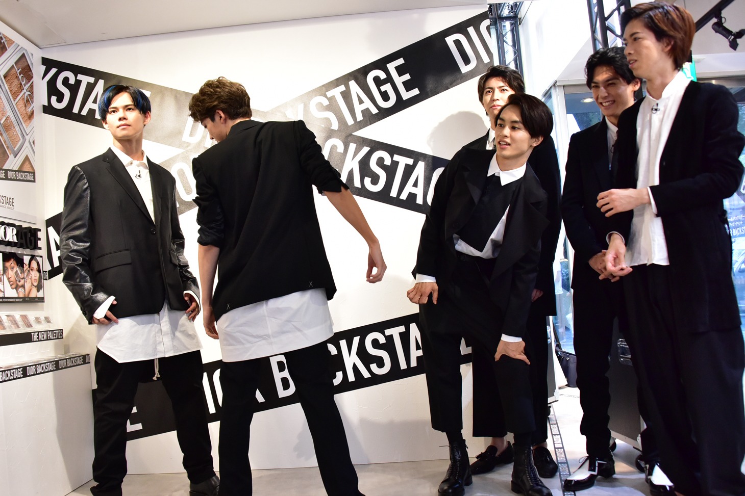 「NYLON」誌面に掲載されるカットを再現するカイとユーキにガヤを入れるメンバー（右）。