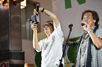 商店街の光景を写メに収める熊倉マネージャー（左）。