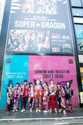 ライブ前、原宿・竹下通りに登場した「SWEET DEVIL」の大型看板前に訪れたSUPER★DRAGON。（撮影：笹森健一）