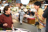 市場の人々とふれあうユースケ（右）。