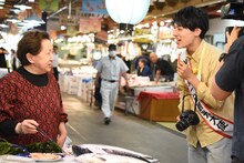 市場の人々とふれあうユースケ（右）。