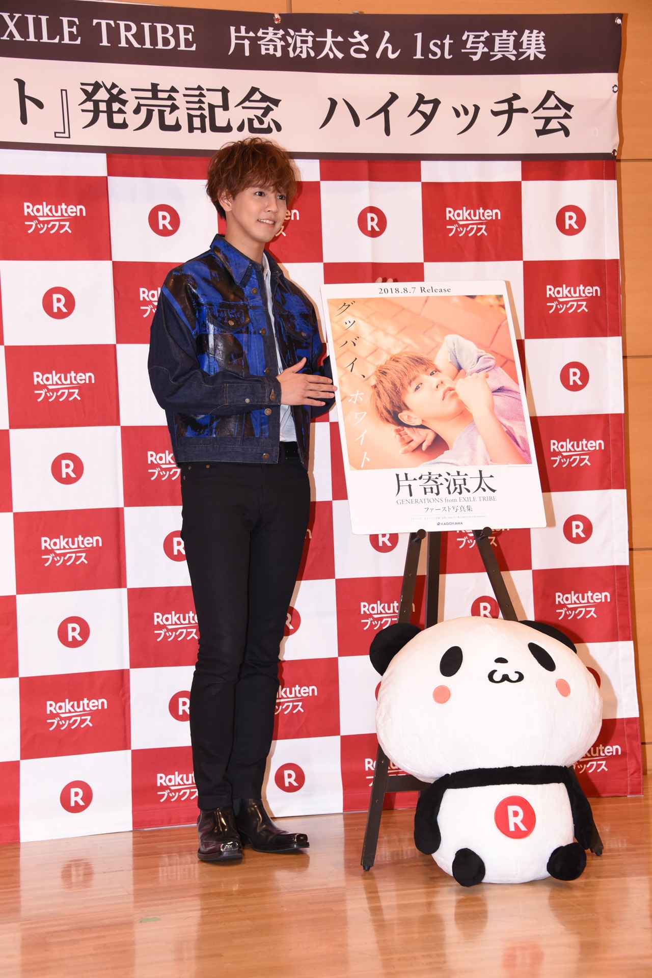 パネルとお買いものパンダと一緒に撮影する片寄涼太。