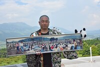 アスペクタのステージで「BEAT CHILD」の写真を抱えるRG。