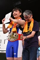 嶺脇社長（右）から金一封とベルトを受け取る我妻桃実（左）。