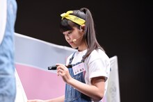 ペンを手にスケッチブックと向き合う藤平華乃。