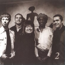 レコーディングに参加したBrand New Heaviesのメンバーやジェイムス・テイラーと共に写真に収まるムッシュかまやつ。