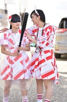 目隠しされた柏木ひなた（左）を誘導する小林歌穂（右）。