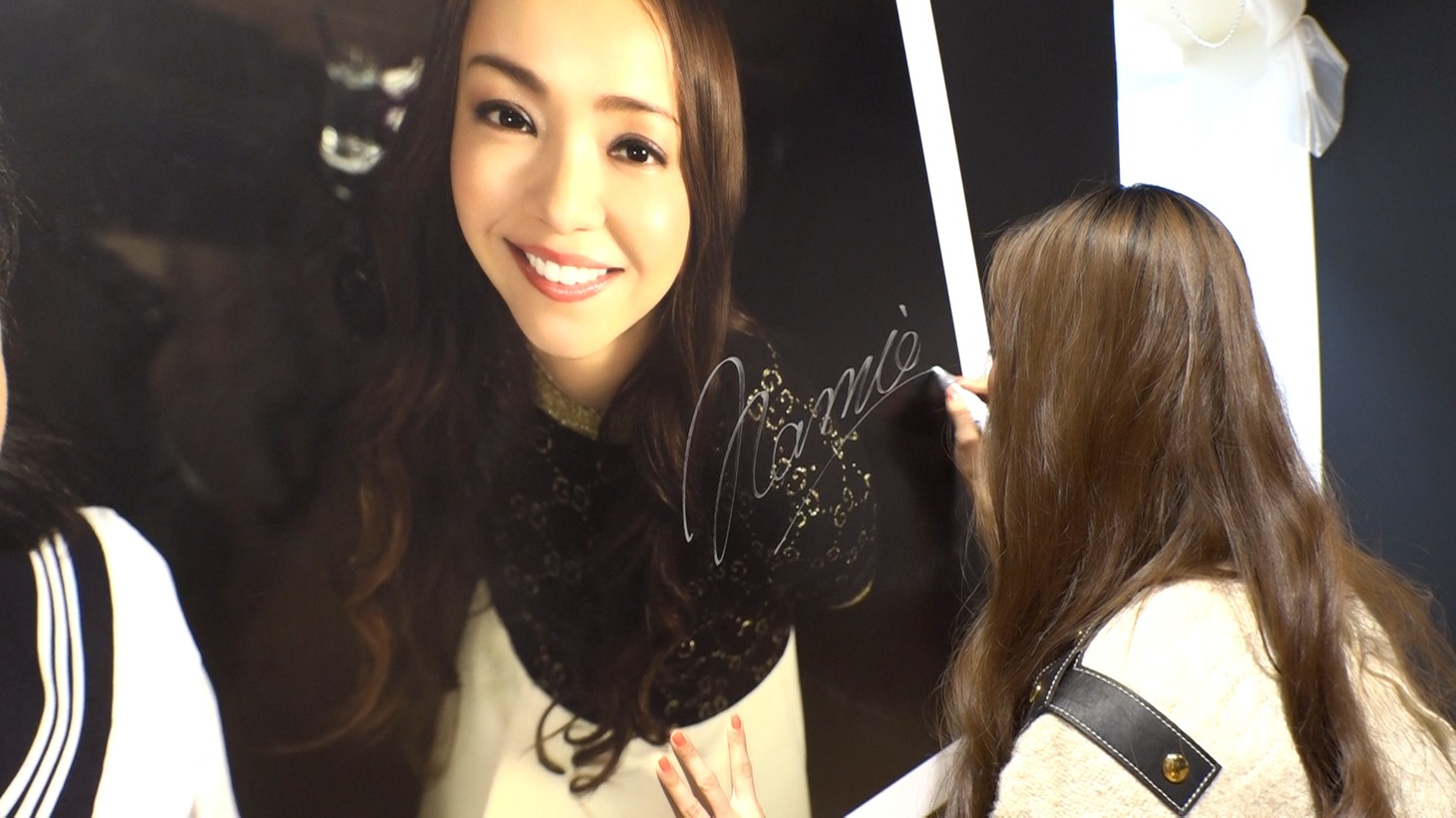 会場内のパネルにサインを入れる安室奈美恵。