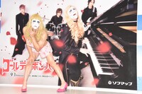 ゴールデンボンバーのアーティスト写真の前でポーズを決める樽美酒研二。