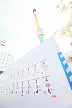 NGT48のポスターが貼られたレインボータワーを囲む壁。(c)AKS