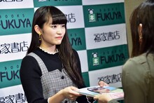 ファンに写真集を手渡す柏木ひなた（私立恵比寿中学）。