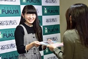 ファンに写真集を手渡す柏木ひなた（私立恵比寿中学）。