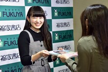 ファンに写真集を手渡す柏木ひなた（私立恵比寿中学）。