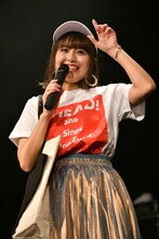 ツアーグッズで身を固め、1つひとつ紹介する脇田もなり。