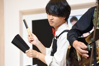 真剣にカウベルを叩く橘柊生。