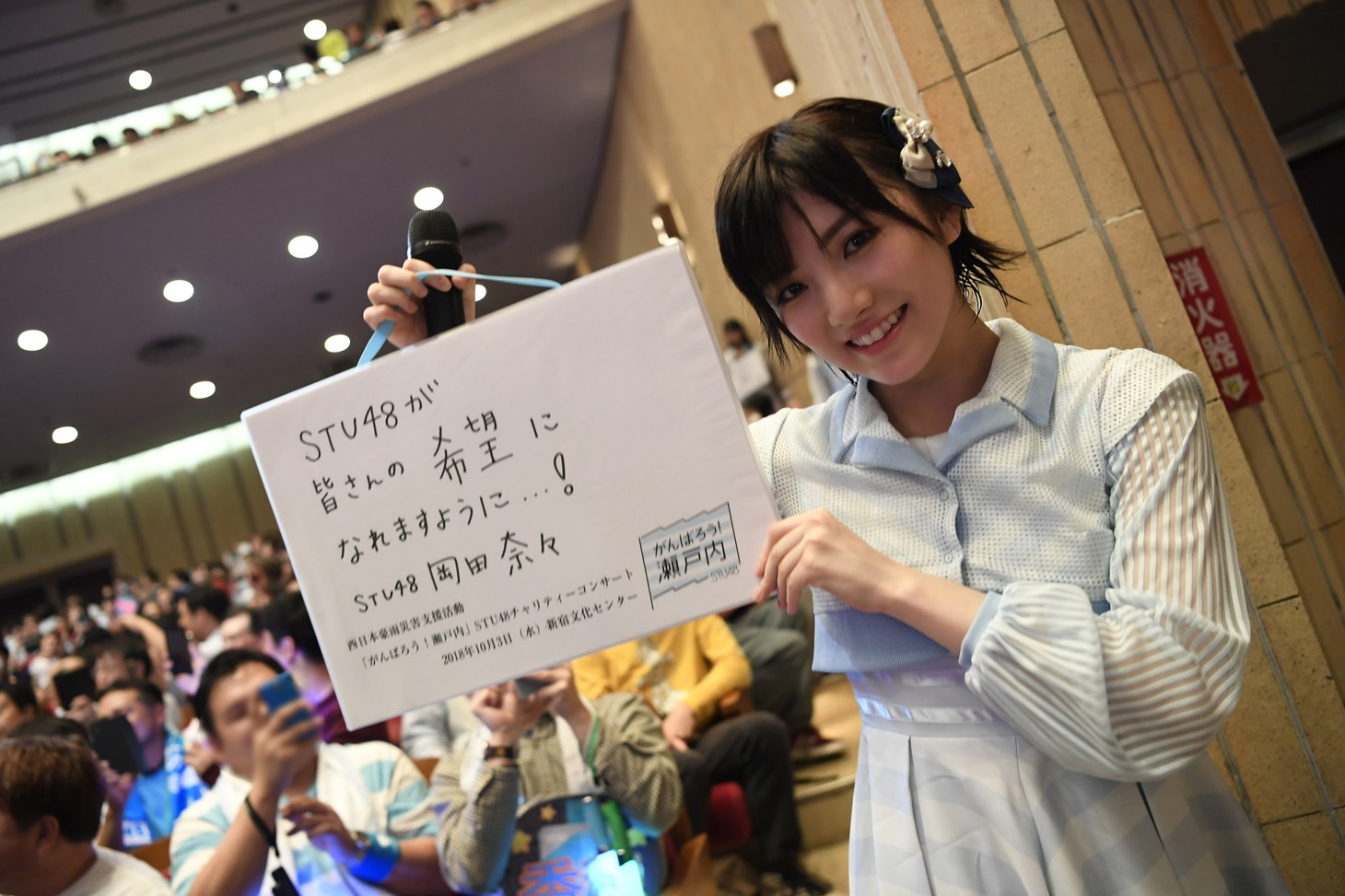 メッセージを掲げる岡田奈々。(c)STU