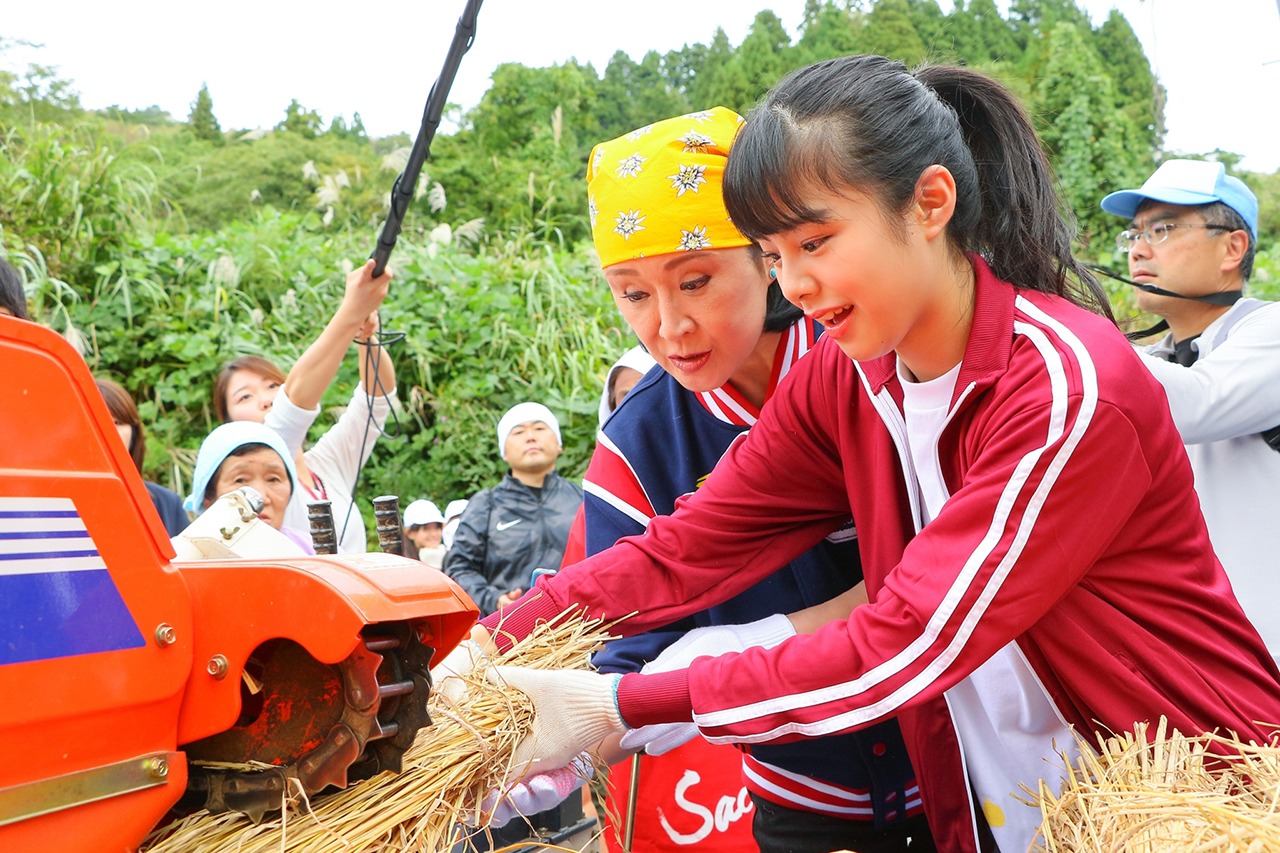 脱穀を行う小林幸子（左）、本間日陽（右）。(c)AKS