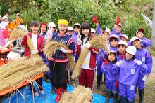 「小林幸子田」で小林幸子や地元の小学生と脱穀を行った本間日陽、日下部愛菜。(c)AKS