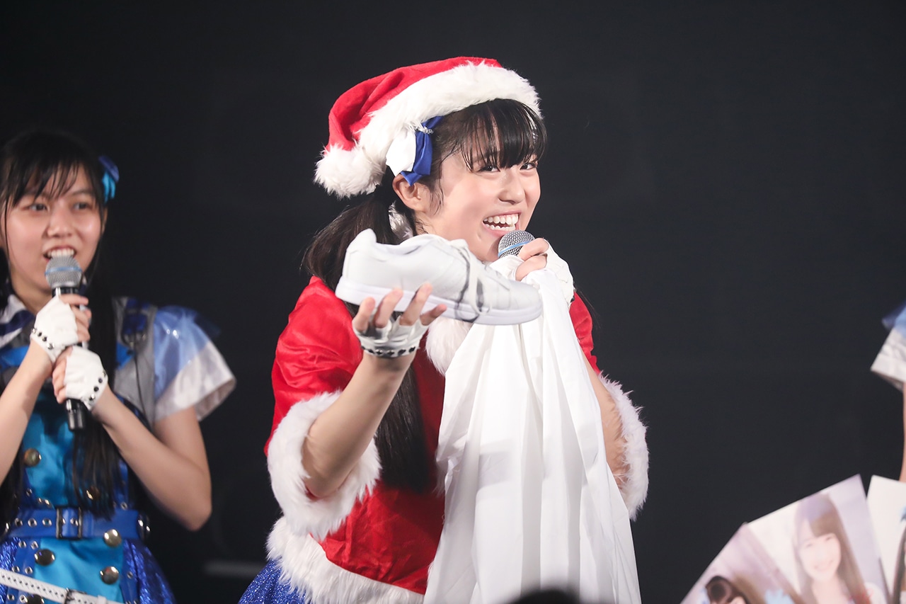 袋からスニーカーを取り出すサンタクロース姿の栗本柚希。（撮影：笹森健一）