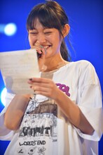 カンペを読みながらニューシングルのリリース情報を発表するminan。