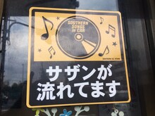 入り口に「Wi-Fiが飛んでます」のステッカーと共に貼られているのは「サザンが流れてます」のステッカー。（画像提供 / happy～みんなのキッチン～）