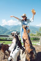 1stソロ写真集「存在」より、マイエンフェルトにあるハイジの村でヤギに囲まれる井上小百合（乃木坂46）。（撮影：前康輔）