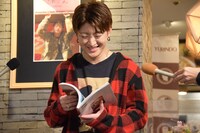 「さのさん」を開いてお気に入りのページを選ぶ佐野玲於。