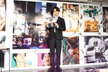 自身の写真がコラージュされた壁面に「特別仕様です！」と笑顔を見せるタクヤ（超特急）。