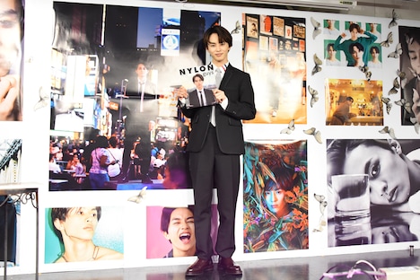 自身の写真がコラージュされた壁面に「特別仕様です！」と笑顔を見せるタクヤ（超特急）。