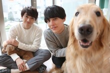 左からトイプードルを抱くユーキ、ユースケ、ゴールデンレトリバー。