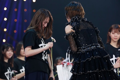 若月佑美（右）に花を渡され涙する桜井玲香（左）。（写真提供：ソニー・ミュージックレコーズ）