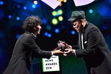 LINE株式会社上級執行役員メディア担当島村武志氏からトロフィーを受け取るくっきー（野性爆弾）。