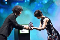 LINE株式会社上級執行役員メディア担当島村武志氏からトロフィーを受け取る若月佑美。