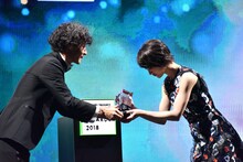 LINE株式会社上級執行役員メディア担当島村武志氏からトロフィーを受け取る若月佑美。