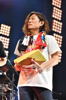 福岡の銘菓「博多通りもん」を手に登場したバンマス宮本將行（B）。