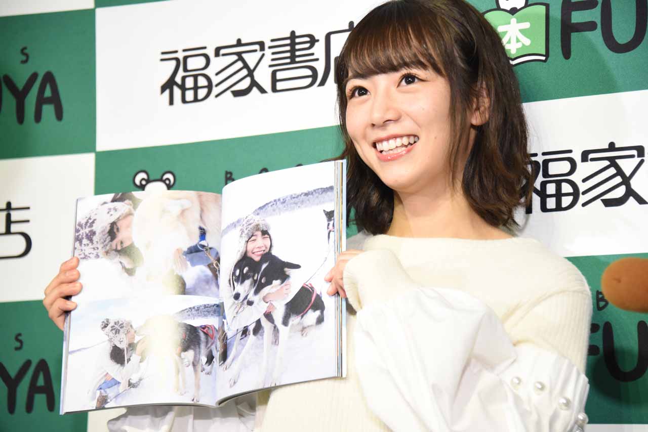 お気に入りの写真が掲載されているページを報道陣に見せる北野日奈子。