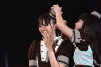 安本彩花（左）の帽子のズレを直す柏木ひなた（右）。