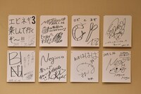 こたつの後ろに飾られたエビネギメンバーのサイン色紙。