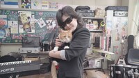 CM撮影時の様子。ふてニャンを抱いたToshl。